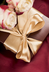 Image showing Bouquet of beautiful roses next to a gift