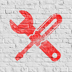Image showing Icon of Crossed Screwdriver on White Brick Wall.