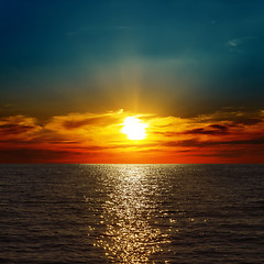 Image showing red dramatic sunset over darken sea