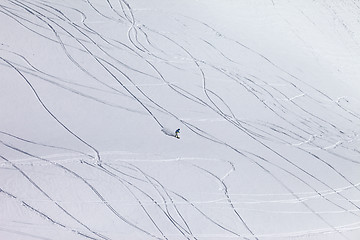 Image showing Snowboarder downhill on off piste slope with newly-fallen snow