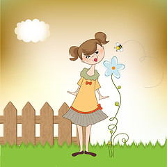 Image showing small young lady who smells a flower