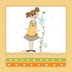 Image showing small young lady who smells a flower