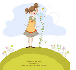 Image showing small young lady who smells a flower