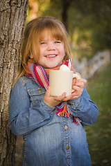 Image showing Cute Young Girl Holding Cocoa Mug with Marsh Mallows Outside
