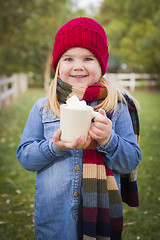 Image showing Cute Young Girl Holding Cocoa Mug with Marsh Mallows Outside