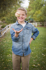 Image showing Handsome Young Boy Tossing Up Baseball in the Park