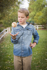 Image showing Handsome Young Boy Tossing Up Baseball in the Park