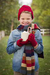 Image showing Young Boy in Warm Clothing Holding Hot Cocoa Mug Outside