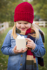 Image showing Cute Young Girl Holding Cocoa Mug with Marsh Mallows Outside