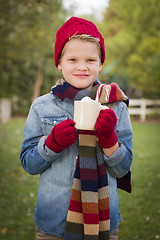 Image showing Young Boy in Warm Clothing Holding Hot Cocoa Mug Outside