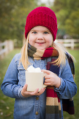 Image showing Cute Young Girl Holding Cocoa Mug with Marsh Mallows Outside