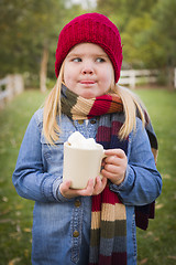 Image showing Cute Young Girl Holding Cocoa Mug with Marsh Mallows Outside