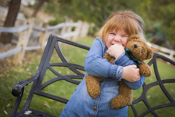 Image showing Cute Smiling Young Girl Hugging Her Teddy Bear Outside