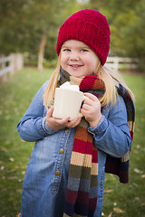 Image showing Cute Young Girl Holding Cocoa Mug with Marsh Mallows Outside