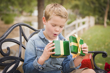 Image showing Suprised Young Boy Opens Christmas Gift Outside