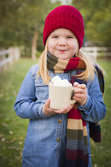 Image showing Cute Young Girl Holding Cocoa Mug with Marsh Mallows Outside