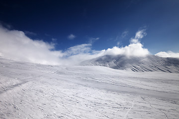 Image showing Ski slope and mountains in clouds