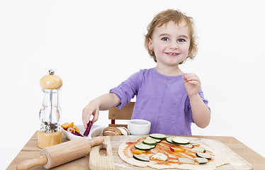 Image showing smiling young girl preparing fresh pizza