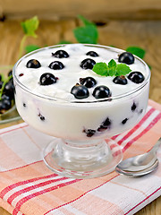 Image showing Yogurt is thick with black currants and spoon on the board