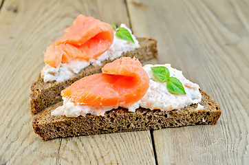 Image showing Sandwiches on bread with salmon and basil on board