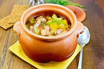 Image showing Roast in a clay pot on a yellow napkin