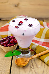 Image showing Yogurt thick with cranberries and spoon on the board