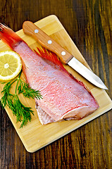 Image showing Fillet of sea bass with dill and knife on board