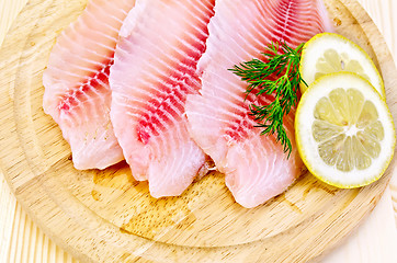 Image showing Fillets tilapia on a round board