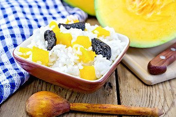 Image showing Rice with pumpkin and a wooden spoon on the board