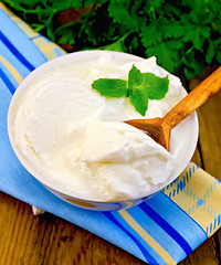 Image showing Yogurt in a white bowl with a wooden spoon and mint