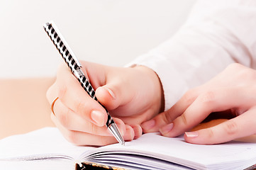 Image showing Woman writing in organizer