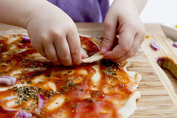 Image showing small hands preparing pizza