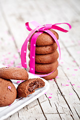 Image showing plate of fresh chocolate cookies with pink ribbon and confetti 