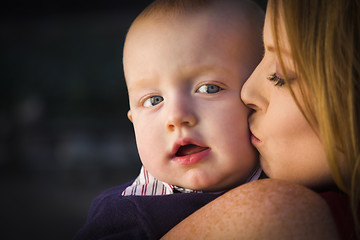 Image showing Adorable Red Head Infant Boy is Kissed By His Mother