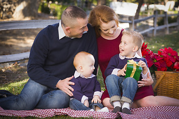 Image showing Small Young Family Opening Christmas Gifts in the Park