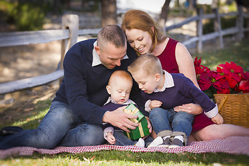 Image showing Small Young Family Opening Christmas Gifts in the Park