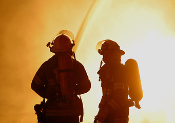 Image showing two firefighters in silhouette