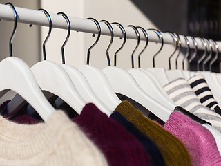 Image showing Clothes hang on a shelf in a store