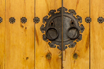 Image showing Traditional metallic door knob with wooden door