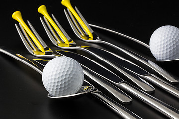 Image showing Forks,spoons and knifes and golf balls