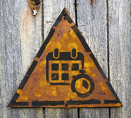 Image showing Calendar with Stopwatch on Rusty Warning Sign.