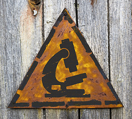 Image showing Microscope Icon on Weathered Warning Sign.