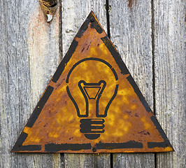 Image showing Light Bulb Icon on Rusty Warning Sign.