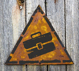 Image showing Briefcase Icon on Rusty Warning Sign.