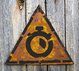 Image showing Stopwatch Icon on Rusty Warning Sign.