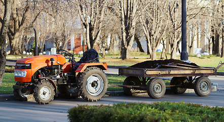 Image showing Orange tractor with a trailer park