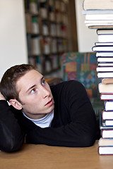 Image showing Student Looking Up At Pile of Books