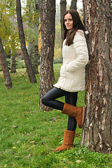 Image showing Lady leaning on tree