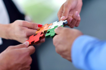 Image showing Group of business people assembling jigsaw puzzle