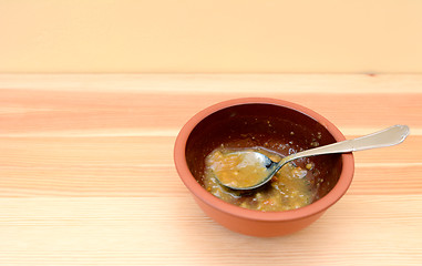 Image showing Empty bowl of soup with a spoon on a wooden table 